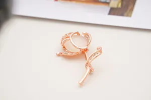 Detailed macro shot of a rose gold flower brooch with white opal and small crystals
