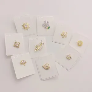 Sammlung zarter goldfarbener Kupferbroschen mit funkelnden Zirkonia-Einlagen auf Displaykarten