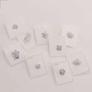 Sammlung zarter Kupfer-Broschennadeln mit funkelndem Zirkonia in verschiedenen Formen.