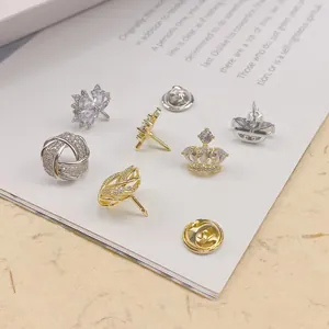 Nahaufnahme verschiedener mit Zirkon besetzter Strickjackennadeln in Gold und Silber