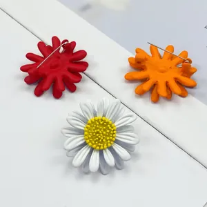 Detailansicht von Gänseblümchen-Broschen in Weiß, Rot und Orange von vorne und hinten