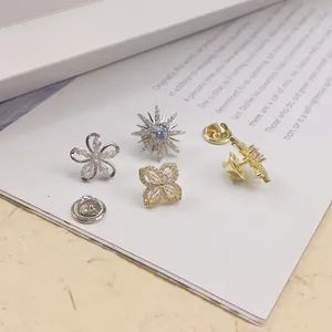 Detailansicht von kupferbesetzten Zirkonia-Sicherheitsnadeln mit Blumen- und Sterndesign