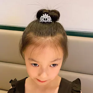 Close-up detail of a sparkling rhinestone tiara hair comb styled on a little girl's bun