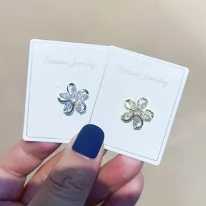 Detailansicht eleganter goldener und silberner Blumenbroschen mit Zirkon-Inlay