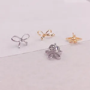 Detailansicht von Mini-Broschen in Schleifen-, Stern- und Blumenform mit Schmetterlingsverschluss