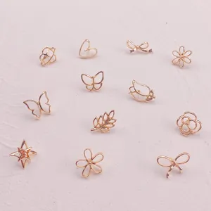Makroansicht goldener Mini-Broschen in Schmetterlings-, Herz- und Blumenform