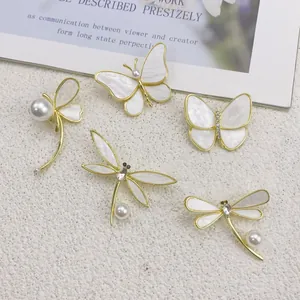 Detailansicht eleganter Schmetterlings- und Libellenbroschen mit Perlen und Goldbeschichtung.