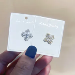 Detailansicht der Schmetterling-Zirkonia-Pins in Gold und Silber auf weißen Karten
