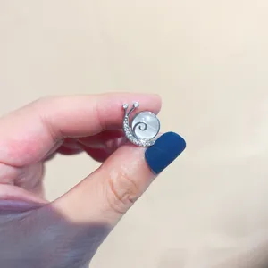 Detailansicht einer silbernen Schneckenbrosche mit Zirkonia und Katzenstein.