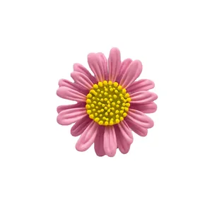 Kleine rosa Gänseblümchen-Brosche mit gelber Mitte auf neutralem weißem Hintergrund