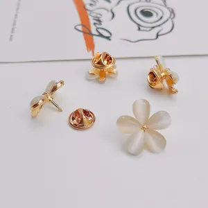 Detail view of elegant cat-eye stone flower and bow brooches with gold-tone metal finish