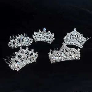 A collection of five sparkling silver rhinestone mini crown hair combs on black velvet