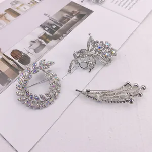 Detail view of three silver rhinestone brooches with shimmering crystal accents.