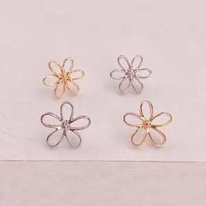 Detailansicht von vier minimalistischen hohlen Blumenbroschen in Gold- und Silberoptik