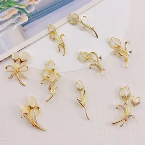Detailed collection of elegant gold tulip brooches with cat's eye stones and crystals.