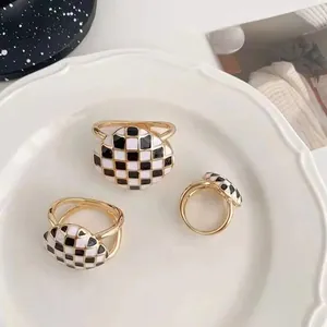 Détail rapproché de l'anneau de boucle de foulard en émail à damier noir et blanc