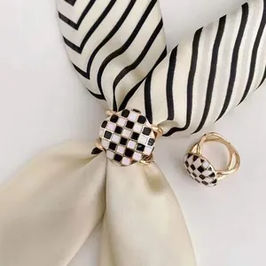 Détail de l'anneau de foulard en émail damier noir et blanc avec finition dorée
