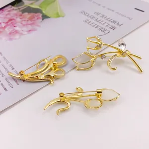 Detailed view of elegant gold tulip brooches with cat's eye stones and crystals