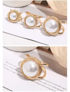 Detailansicht eleganter goldener Seidenschal-Schnallen mit großen Perlen auf Papier