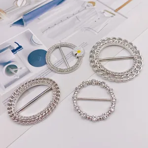 Detailansicht von vier verschiedenen silbernen Strass-Schalringen und T-Shirt-Knotenschnallen