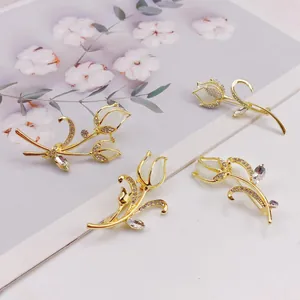 Macro view of elegant gold-toned tulip brooches with cat's eye stones and rhinestones.