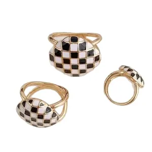 Bague boucle de foulard dorée avec un motif en damier classique en émail noir et blanc