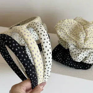 Detail view of floral padded headbands and matching fabric scrunchies in soft tones.