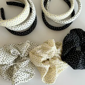 Close-up of floral fabric scrunchies and matching wide headbands in various colors