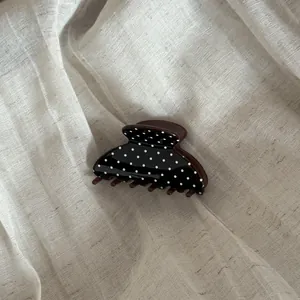 Eleganter schwarz-weißer Haarkrebs aus Acetat mit Punkten auf Leinenhintergrund