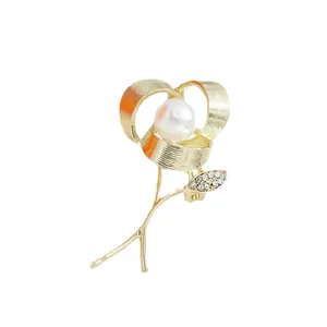 Elegant gold-tone rose flower brooch with central pearl and crystal-encrusted leaf detail