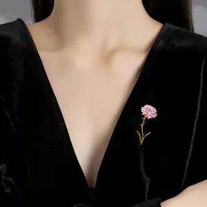 Elegant enamel carnation brooch pin shown worn on a black velvet dress for women
