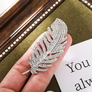 Detailed macro view of a luxury silver feather brooch encrusted with sparkling clear rhinestones