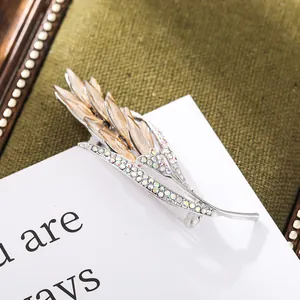 Close-up of elegant wheat ear brooch with champagne crystals and iridescent rhinestones.
