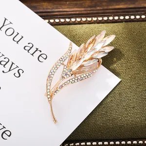 Close-up of an elegant gold wheat ear brooch featuring sparkling champagne crystals