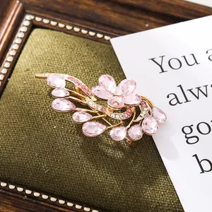 Close-up of elegant pink crystal flower brooch with shimmering gold-tone finish