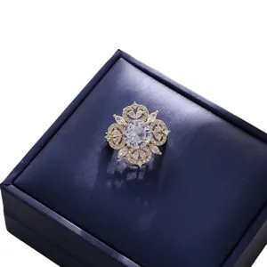 Ornate vintage palace style gold-toned brooch with clear crystals on navy gift box