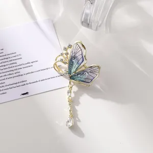Vista macro detallada de un broche de mariposa traslúcido con elegante borla de cristal