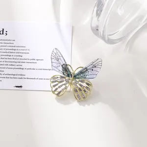 Detalle de un elegante broche de mariposa con alas translúcidas y detalles de pedrería