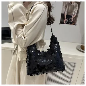 Élégant sac sous l'aisselle à paillettes noires avec une tenue beige minimaliste