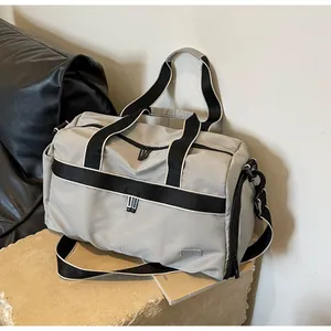 Side view of a large gray oxford cloth travel bag with black shoulder straps and zipper