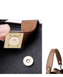 Detalle del cierre magnético dorado en un bolso de cubo de cuero negro texturizado