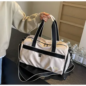 Detail view of a large cream Oxford cloth travel tote bag with stylish black straps.
