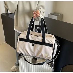 Durable beige Oxford travel tote bag with trolley sleeve on a white rolling suitcase