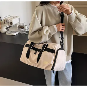Asian woman carrying a beige large capacity Oxford travel tote bag on her shoulder
