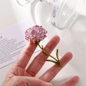Detailed close-up showing an elegant purple enamel carnation flower brooch held in hand