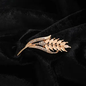 Close-up of luxury wheat ear brooch with cat-eye stones and rhinestones on black velvet