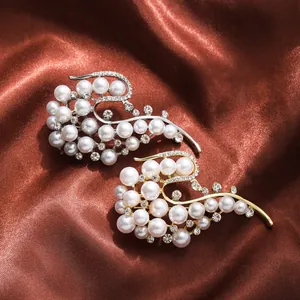 Detailed view of elegant gold and silver pearl brooches with shimmering rhinestones on silk