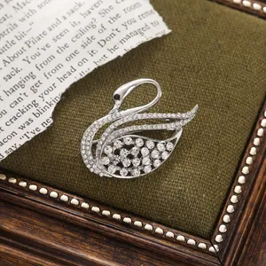 Close-up of elegant silver-toned swan brooch encrusted with sparkling white rhinestones