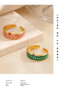 Detalle de anillos retro de esmalte y acero inoxidable con lunares dorados y diseño abierto.