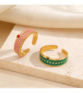 Primer plano de anillos abiertos retro de acero inoxidable esmaltado con diseño de lunares.